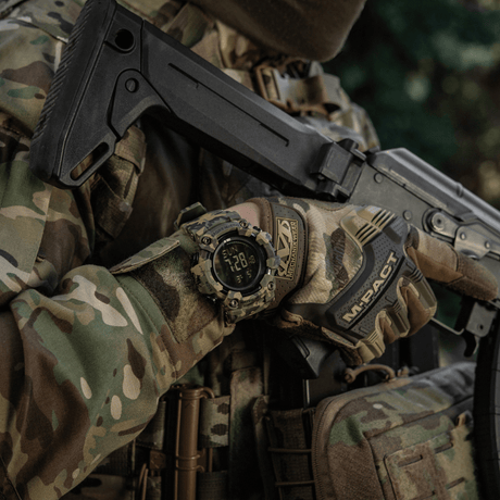 M-Tac Tactical Ur 2037 henkilöllä maastovarusteissa ja aseen kanssa.