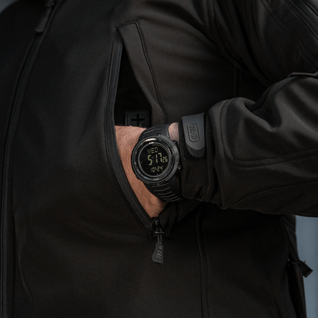 Henkilö käyttää M-Tac Tactical Ur 2147:ää, tukeva muotoilu ja LED-taustavalo, sopii ulko- ja päivittäiseen aktiivisuuteen.