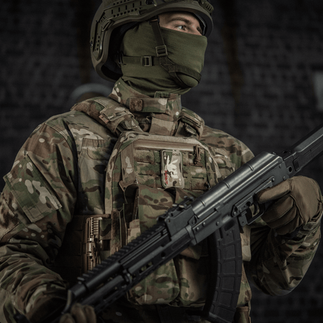 Sotilas maastopuvussa, M-Tac Patch Bad Boy (brodeerattu) liivissä, varustautunut rynnäkkökiväärillä, symboloi voimaa ja rohkeutta.