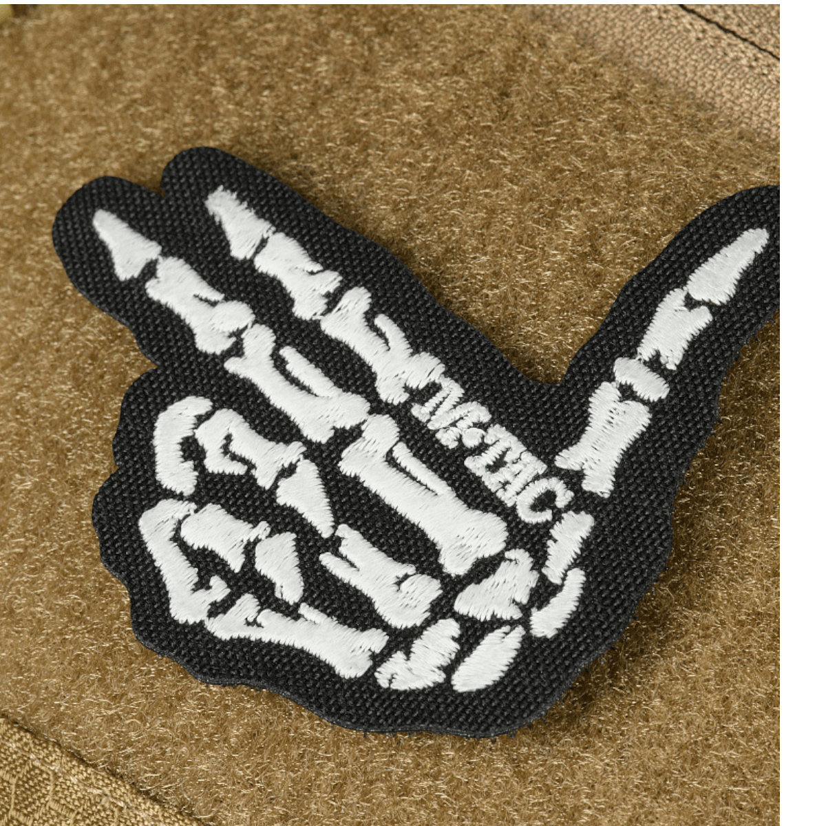 M-Tac Bat Wing Taske Elite Hex med skelet håndtegn broderi i sort og hvid på holdbart stof.