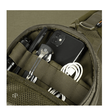 Yksityiskohta M-Tac Buckler Taske Elite Hexistä, taskut täynnä työkaluja ja elektroniikkaa, esittelee älykkään suunnittelun toiminnallisuuden.