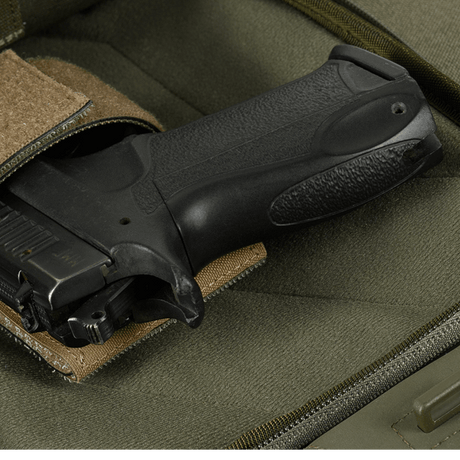 Kuva M-Tac Buckler Taske Elite Hexistä, piilotettu asekotelo ja MOLLE-järjestelmä harmaalla taustalla.
