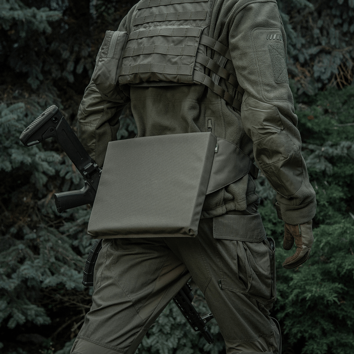 Person iført taktisk udstyr med M-Tac Siddeunderlag med bælte i skovmiljø