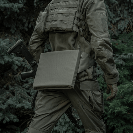 Person iført taktisk udstyr med M-Tac Siddeunderlag med bælte i skovmiljø