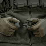 Præsentation af M-Tac Siddeunderlag med bælte brugt i taktisk miljø med handsker, klar til kold vejr udendørs aktiviteter.