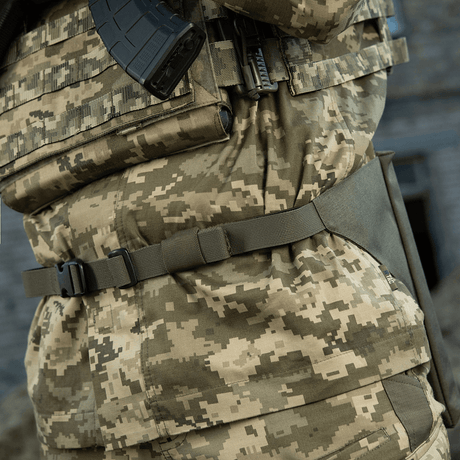 M-Tac Siddeunderlag med bælte i camouflage, set i brug udendørs.