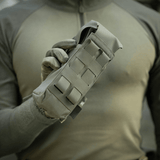 M-Tac Dobbelt Magasin Taske med Fastex Lukning holdt af mand i militærgrønt tøj, designet til AR- og AK-seriens magasiner.