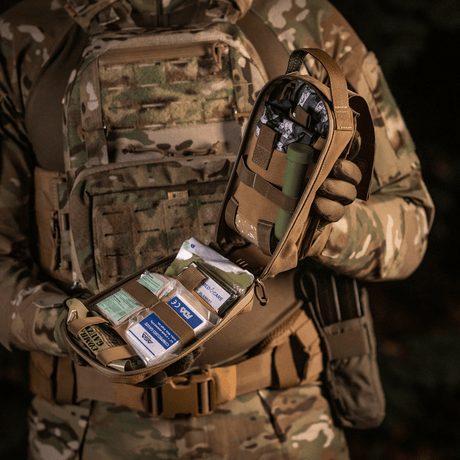 M-Tac Medical Pouch Rip Off monteret på camouflageudstyr med velcro, åbnet for at vise opbevaring af førstehjælpskit. Hurtig adgang via lynlås.