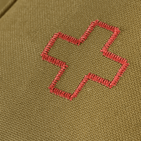 Nærbillede af M-Tac Medical Pouch Rip Off med rødt korsbroderi på olivengrøn baggrund, designet til førstehjælp og hurtig adgang.