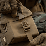 Person iført handsker åbner M-Tac Taske til Natkikkert PVS-14 med fastex-lukning, designet til sikker opbevaring af natkikkerter.