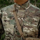 Person i camouflagejakke med rem, udstyret til udendørs aktiviteter