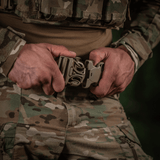 Soldat justerer M-Tac War Belt ARMOR med slidstærkt Cordura og MOLLE-webbing, perfekt til taktisk brug.