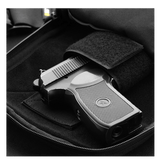 Pistol i M-Tac Carry Sling Taske Elite Gen.IV med Velcro, designet til skjult bæring med universelt velcro-hylster, klar til hurtig adgang.