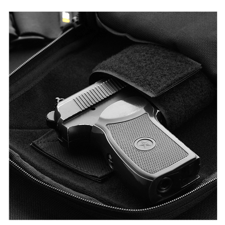 Pistol i M-Tac Carry Sling Taske Elite Gen.IV med Velcro, designet til skjult bæring med universelt velcro-hylster, klar til hurtig adgang.