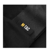 Close-up of the M-Tac logo on a black fabric, showcasing the durable material of the M-Tac Carry Sling Taske Elite Gen.IV med Velcro.