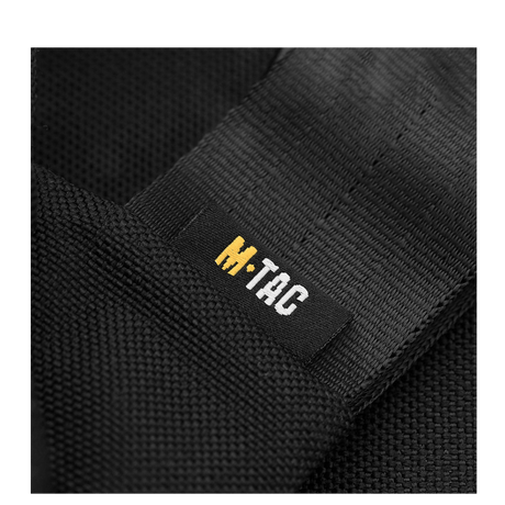 Close-up of the M-Tac logo on a black fabric, showcasing the durable material of the M-Tac Carry Sling Taske Elite Gen.IV med Velcro.