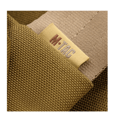 Nærbillede af M-Tac Carry Sling Taske Elite Gen.IV med Velcro, der viser mærket i beige og olivengrønne nuancer.