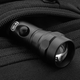 Lommelygte i en M-Tac Carry Sling Taske Elite Gen.IV med Velcro lomme, designet til skjult og sikker bæring af udstyr.