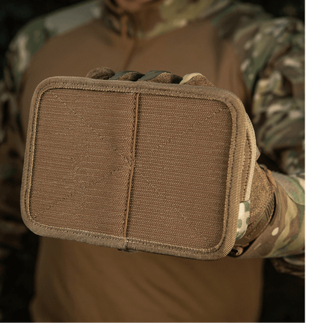 M-Tac Hook & Loop Utility Panel med hook-fastener, set foran i camouflagebaggrund.