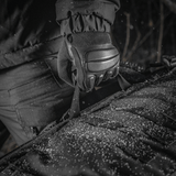 Nærbillede af M-Tac Rygsæk Gen.II Elite Large i Cordura materiale, holdt af handske i snevejr