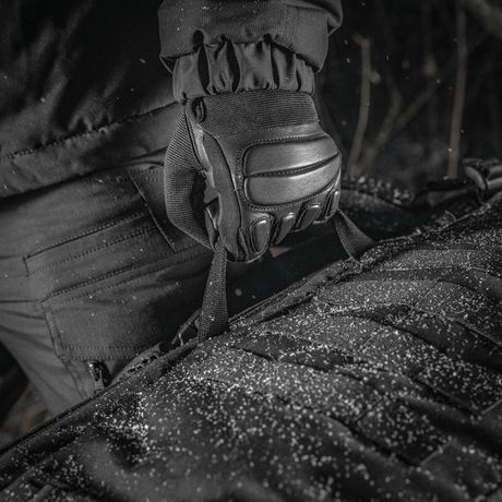 Nærbillede af M-Tac Rygsæk Gen.II Elite Large i Cordura materiale, holdt af handske i snevejr