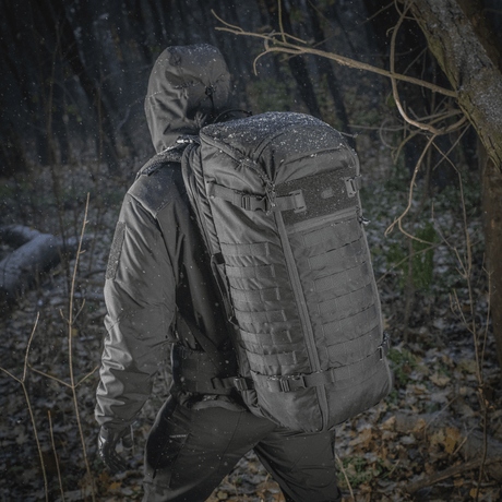 Person bærer M-Tac Rygsæk Gen.II Elite Large i skovmiljø