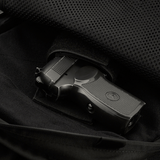 Indvendigt rum i M-Tac Magnet XL Bag Elite med universalholster, vist med pistol, fremhæver funktionalitet og sikkerhed i tasken.
