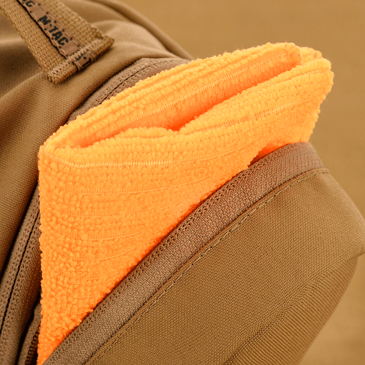Nærbillede af M-Tac Toilettaske Elite Gen.II med en orange håndklæde i lommen, der fremhæver taskens praktiske design.