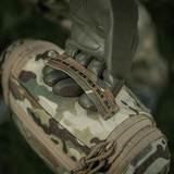 M-Tac Toilettaske Elite Gen.II i camouflage design, holdt af en hånd med taktiske handsker til udendørs brug.