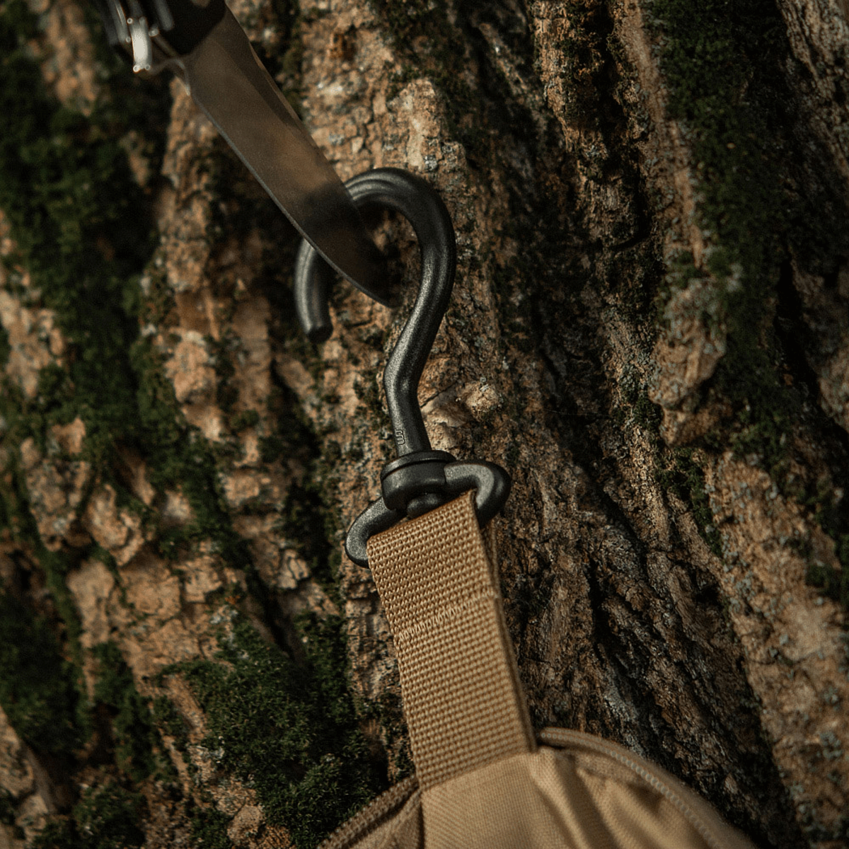 Krogdetalje på M-Tac Toilettaske Elite Gen.II, hængende på træ, ideel til opbevaring af hygiejneartikler på rejser.