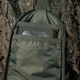 M-Tac Toilettaske Elite Gen.II hængende på et træ, viser indvendig opbevaringsplads til hygiejneartikler, ideel til rejser.