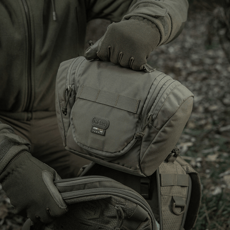 Person holder M-Tac Toilettaske Elite Gen.II designet til rejser og opbevaring af hygiejneartikler i naturen.