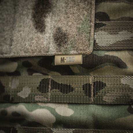 M-Tac Panel til Patches på MOLLE 120x85 med hook & loop overflade og plastbase for stabilitet, fastgjort til camouflage MOLLE-system.