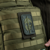 M-Tac Panel til Patches på MOLLE 80x135 fastgjort til en rygsæk med patch-design, ideel til tilpasning af MOLLE-systemer.