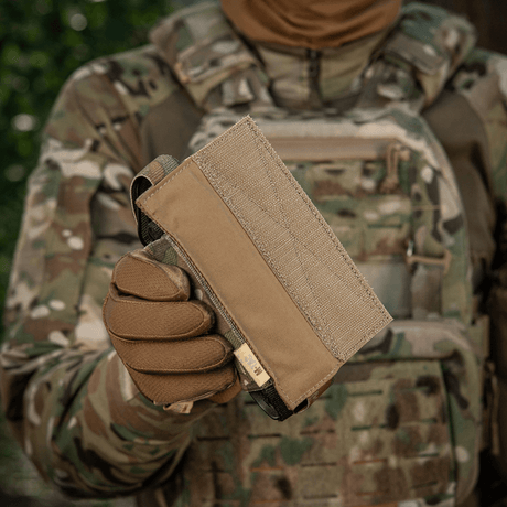 M-Tac Tourniquet Pouch Elastisk VELCRO Gen.II i camoufleret omgivelser, holdt af taktisk udstyret person