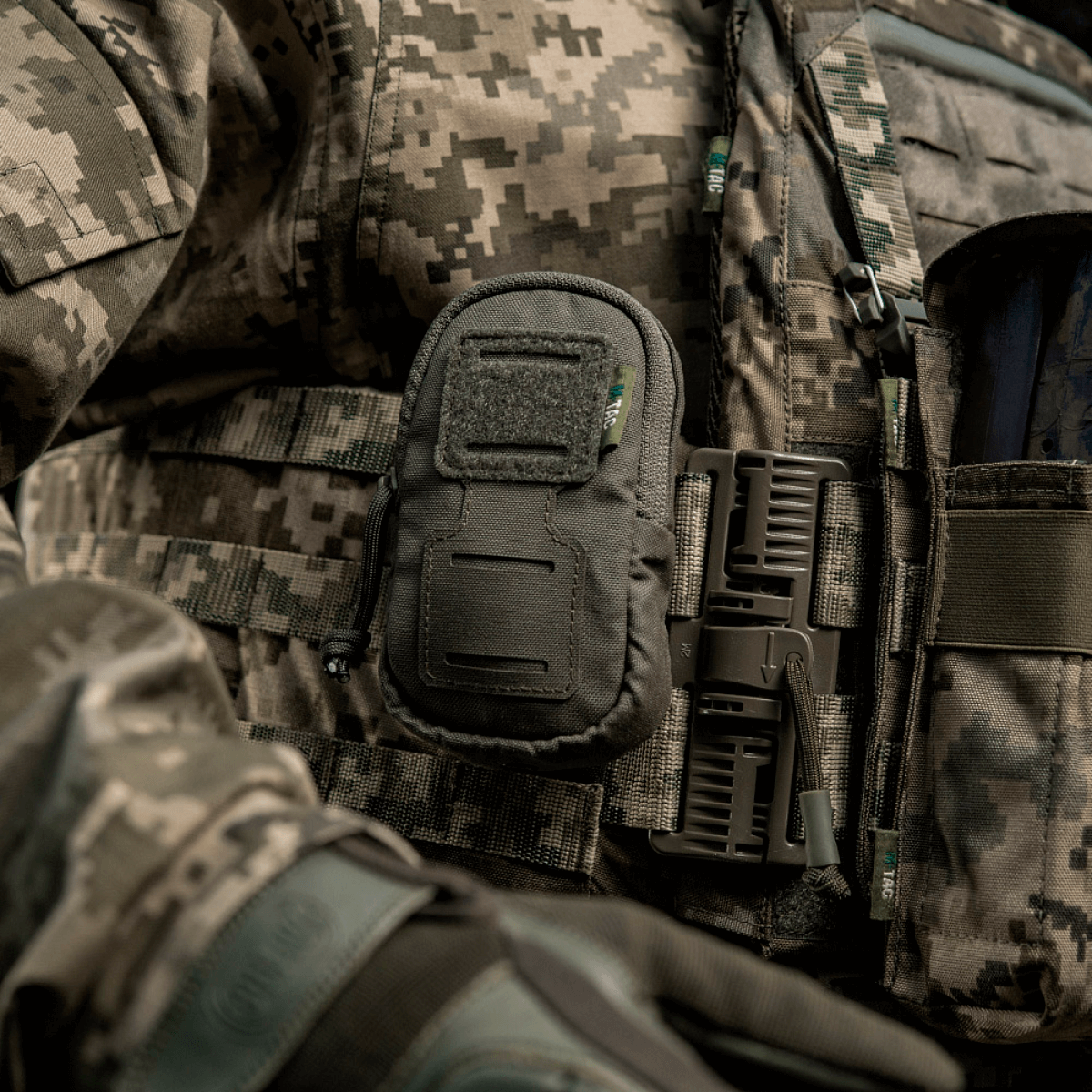 M-Tac PC Utility Pouch Elite monteret på taktisk vest med MOLLE-interface og Velcro-panel, ideel til opbevaring og dræn i bunden