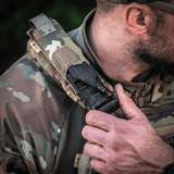 M-Tac Tourniquet Pouch Elastisk med MOLLE Gen.II fastgjort på skulder af en taktisk vest, viser hurtig adgang og holdbarhed.