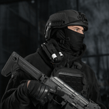 Taktisk person iført sort tøj og hjelm med våben og udstyr, klar til mission.