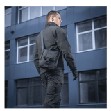 Mand bærer M-Tac Satellite Magnettaske Gen. II Elite Hex i en urban setting, iført taktisk tøj.