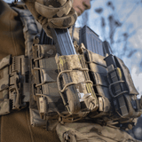 Taktisk udstyr med M-Tac Pistol Mag Pouch Gen.3 monteret på MOLLE-system, set i brug udendørs.