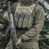 M‑Tac Elastisk Triple Magazine Pouch Elite monteret på taktisk vest med tre magasiner og et riflegevær i hånden.