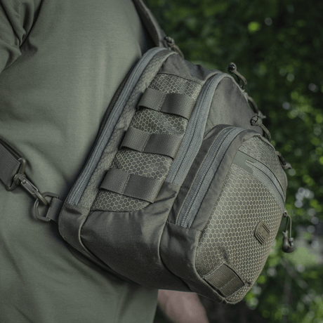 M‑Tac Cross Bag Elite Hex sling pack i Cordura 500, set på skulder i grønne omgivelser, perfekt til daglig brug og taktisk udstyr. 5 liter.