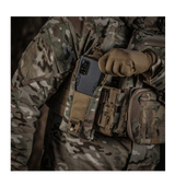 M-Tac Smartphone Lomme Elite Large Hex med smartphone op til 6,5 tommer i camouflagetøj i militærsetting.