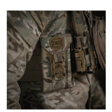 M-Tac Smartphone Lomme Elite Large Hex i CORDURA HEX materiale, vist monteret på taktisk udstyr med en camouflagebaggrund.