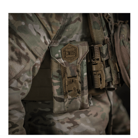 M-Tac Smartphone Lomme Elite Large Hex i CORDURA HEX materiale, vist monteret på taktisk udstyr med en camouflagebaggrund.
