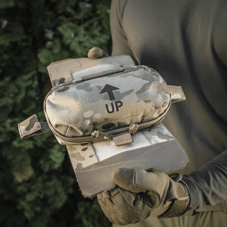 M‑Tac Horizontal Medical Pouch Elite holdt af person i natur, camouflage design og Cordura 500D materiale.
