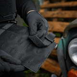 En person justerer M‑Tac Front Panel til Cuirass QRS med Woojin kroge og Velcro, lavet af Cordura 500D, til militært brug.