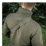 Mand bærer M-Tac Sling Pistoltaske Elite Hex med justerbar skulderrem i en udendørs setting