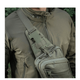 M-Tac Sling Pistoltaske Elite Hex i brug, bæret på skulder med justerbar rem og hurtigspænde, lavet af holdbart Cordura 1000D og Hex.