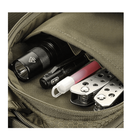 Detalje af M-Tac Sling Pistoltaske Elite Hex med lommelygte, multitool og kuglepen synlige i lommen.